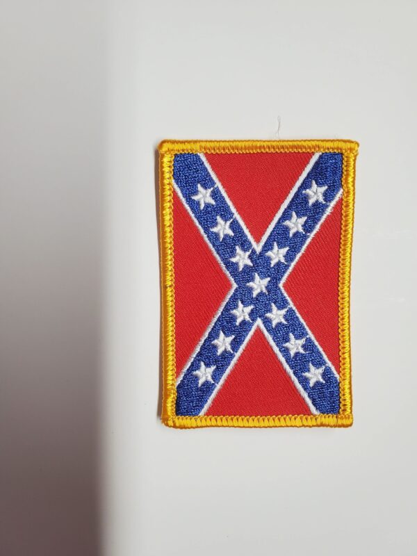 A patch of the confederate flag is hanging on a wall.