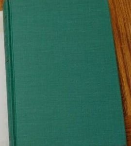 A book with green cover on top of wooden table.