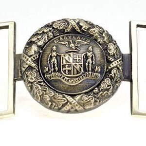 A belt buckle with the coat of arms on it.