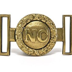 A brass buckle with the letters nc on it.