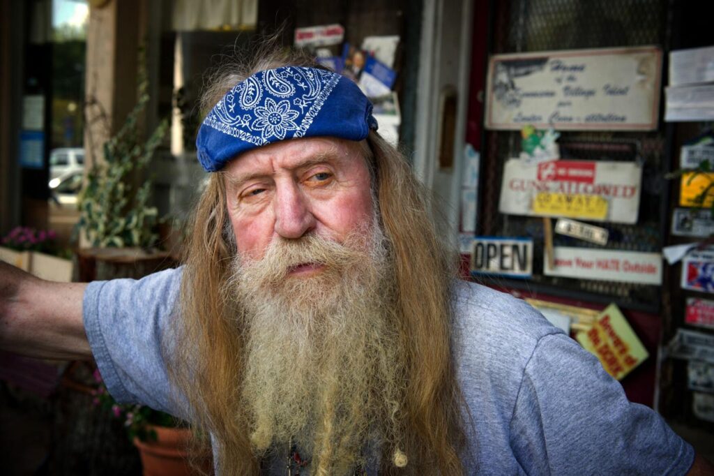A man with long hair and a blue bandana on his head.