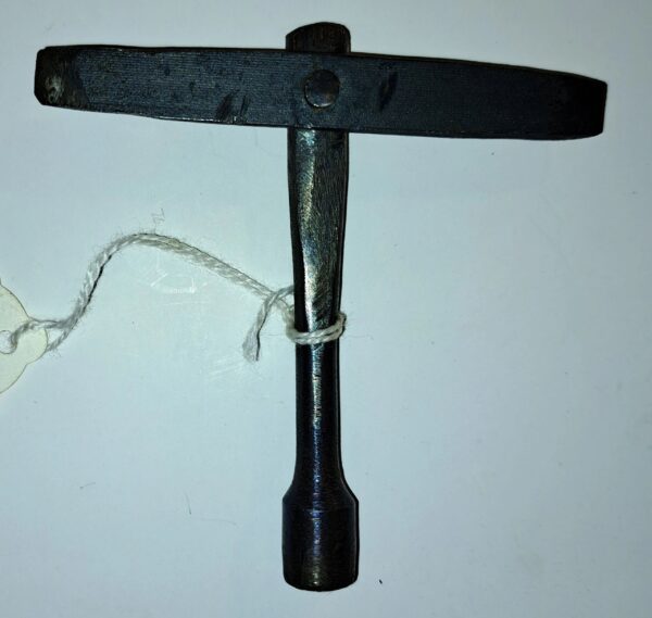 A black wrench with white string hanging from it.